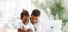 man and woman sitting on white couch